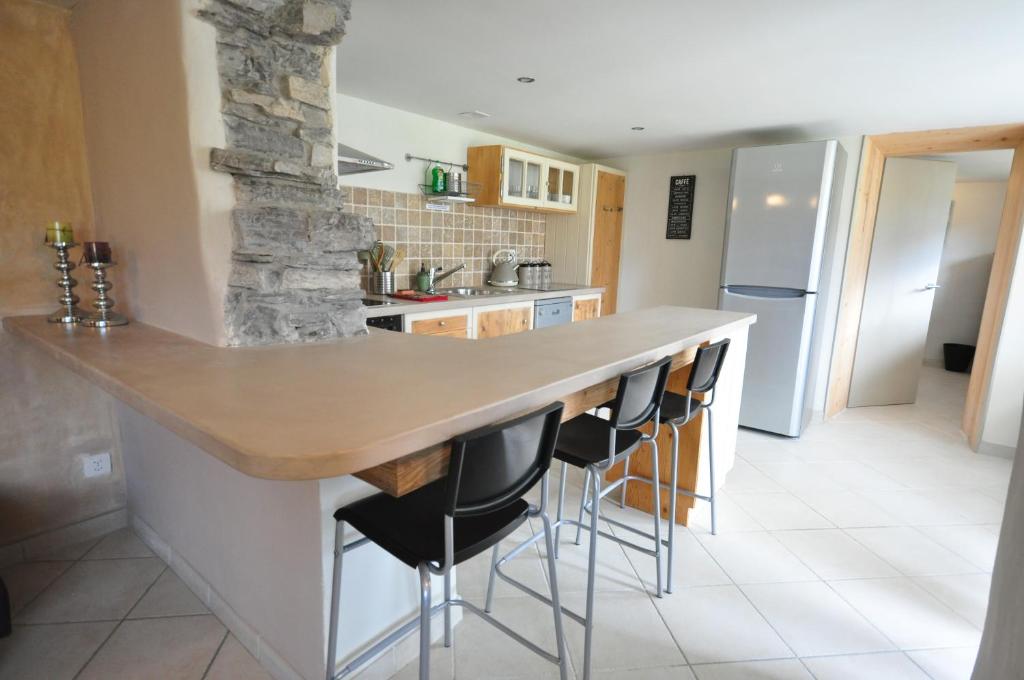 a kitchen with a counter and bar stools at Lakeside Apartment in Ringgenberg