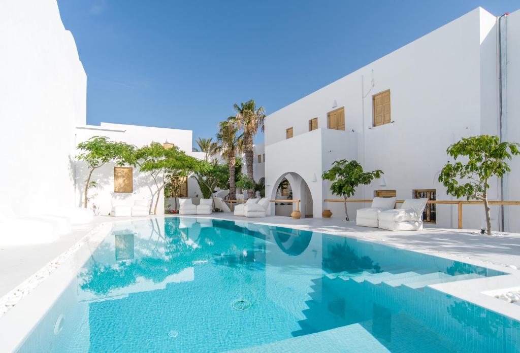 a swimming pool in front of a white building at Santorini Crystal Blue Boutique Hotel in Kamari