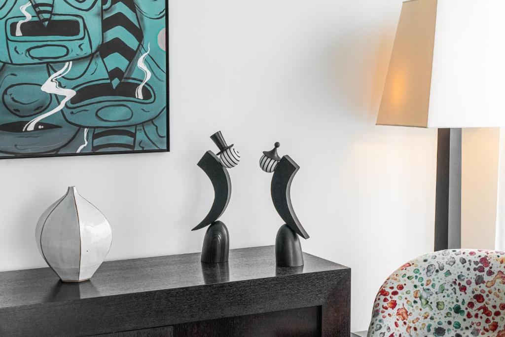 un salon avec deux sculptures noires sur une commode dans l'établissement Spacious duplex in the heart of Bordeaux, à Bordeaux