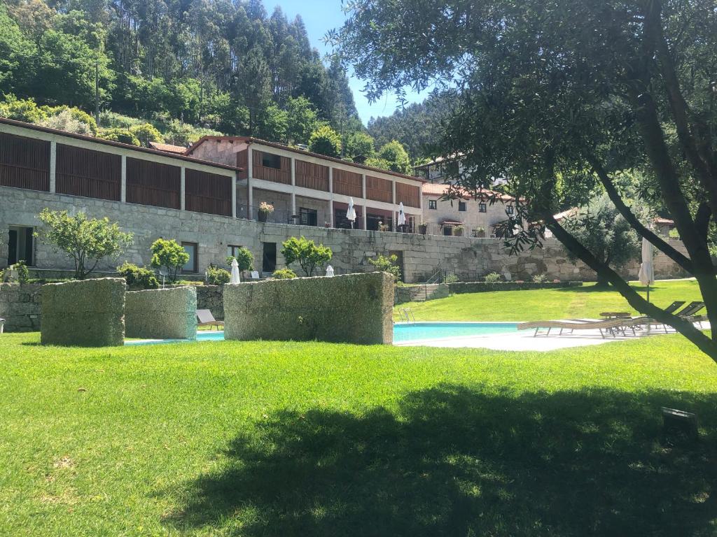 a building in a park with a field of grass at Quinta de Barbêdo - Turismo Rural in Caniçada