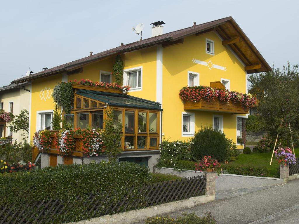 una casa amarilla con flores. en Haus Kloibhofer, en Grein