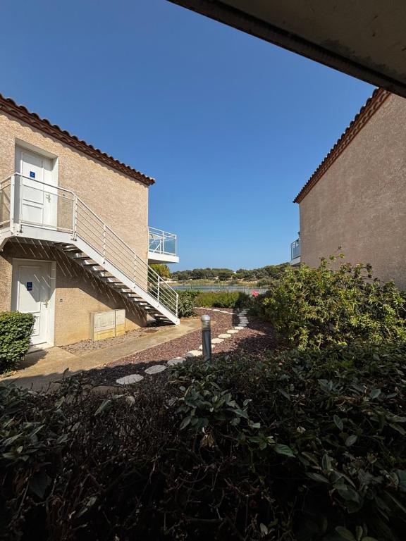 a stairway leading to a building with a balcony at Appartement climatisé Résidence Goélia Les Jardins De Phoebus in Gruissan