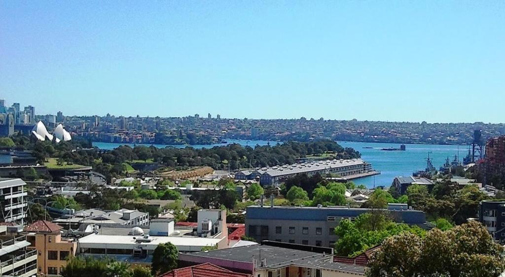 a view of a city with a river and buildings at Spacious apartment with stunning harbour view in Sydney