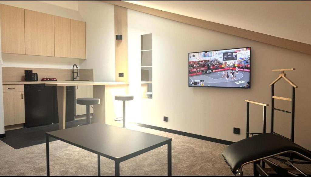 a living room with a tv hanging on a wall at Suite sous les toits 25m2 à 1mn du port de CASSIS in Cassis