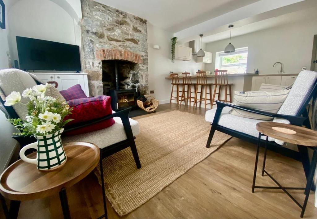 a living room with a couch and a fireplace at Morfarch traditional stone cottage within Conwy walls in Conwy