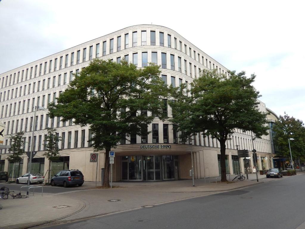 a large white building with trees in front of it at City Lodge Hannover in Hannover