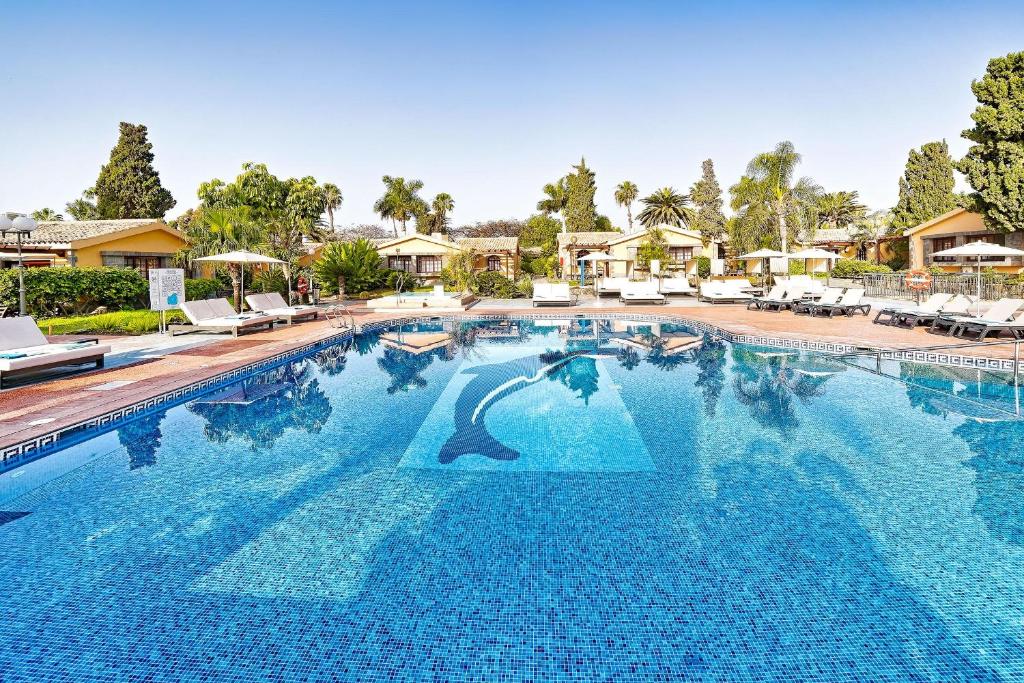 a large swimming pool with blue water in a resort at Maspalomas Villas by Dunas - Adults Only in Maspalomas