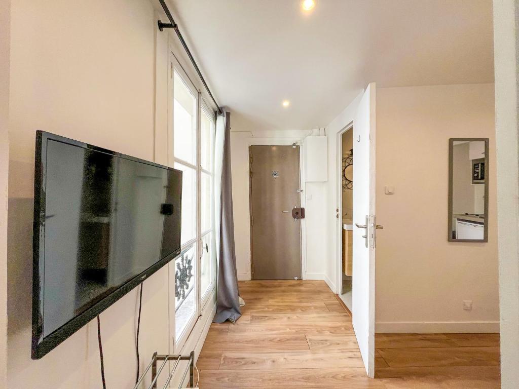 un salon avec une télévision à écran plat sur un mur dans l'établissement 148 - Urban Studio in Paris, à Paris