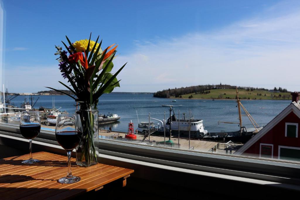 un tavolo con due bicchieri di vino e un vaso di fiori di Rum Runner Inn a Lunenburg