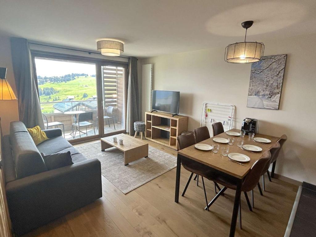 - un salon avec une table à manger et un canapé dans l'établissement Appartement 3 pièces avec parking couvert, proche commodités - FR-1-594-331, à Hauteluce