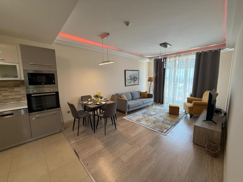 a kitchen and living room with a table and a couch at Leona Lux Apartment Skopje in Skopje