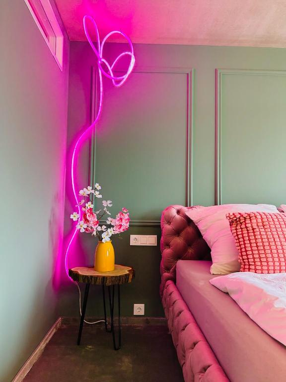 a room with a bed and a table with flowers at PenthouseNeuruppin direkt am See in Neuruppin