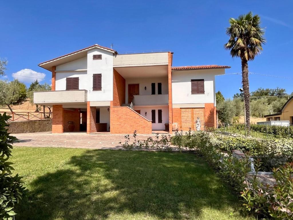 une maison avec un palmier devant dans l'établissement Villa Fontalta, à Cavriglia