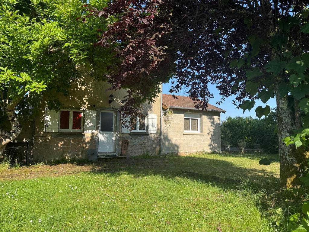 a small stone house with a tree in the yard at Maison familiale à Fresselines, jardin, rivière in Fresselines