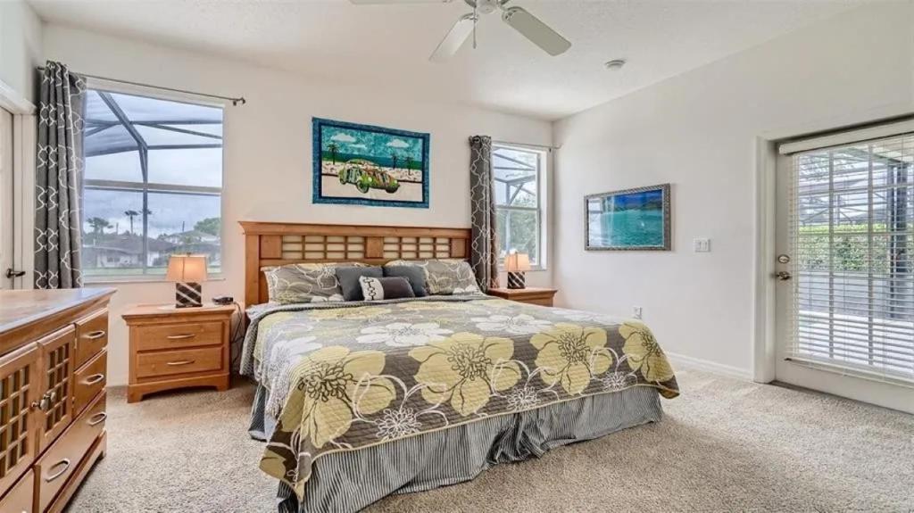a bedroom with a bed and a dresser and windows at 509 Relax Play at This 6BR Pool Home in Haines City