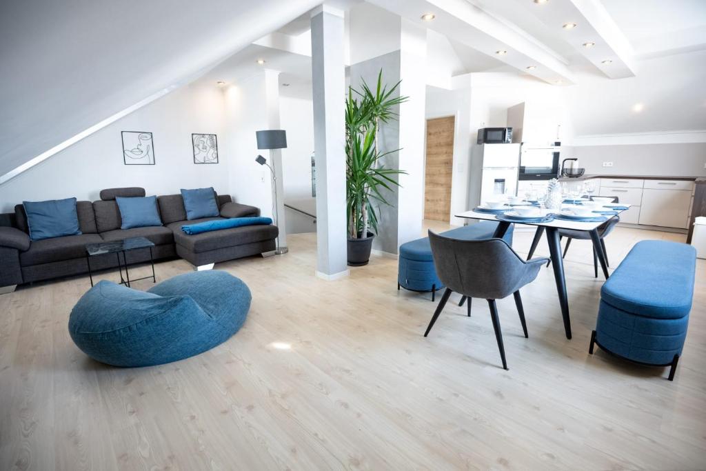 een woonkamer met een bank, een tafel en stoelen bij CASA 8070 - Modern Living - Große Maisonette für Familien, Gruppen & Geschäftsreisende in Ingolstadt