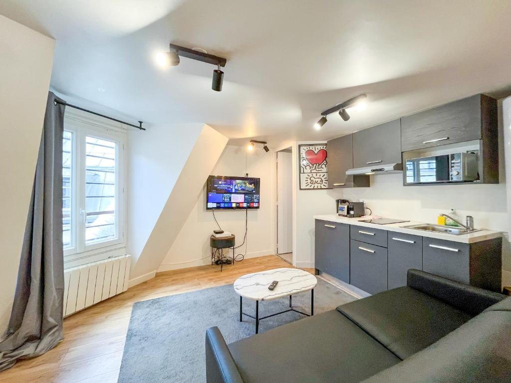un salon avec un canapé et une cuisine dans l'établissement Urban Flat 150 - Pretty Flat in Center of Paris, à Paris