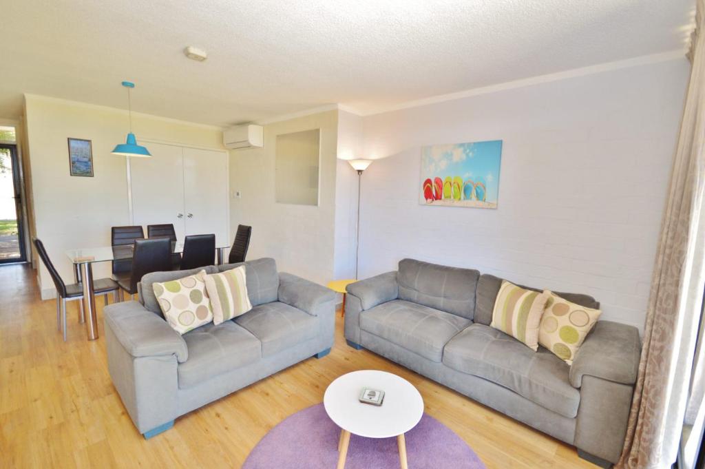 ein Wohnzimmer mit zwei Sofas und einem Tisch in der Unterkunft Riverview Holiday Apartment 19 - Kalbarri, WA in Kalbarri