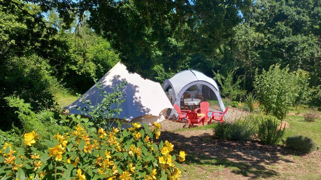 une tente et des chaises dans un jardin fleuri dans l'établissement Tente insolite en pleine nature, à Tréduder