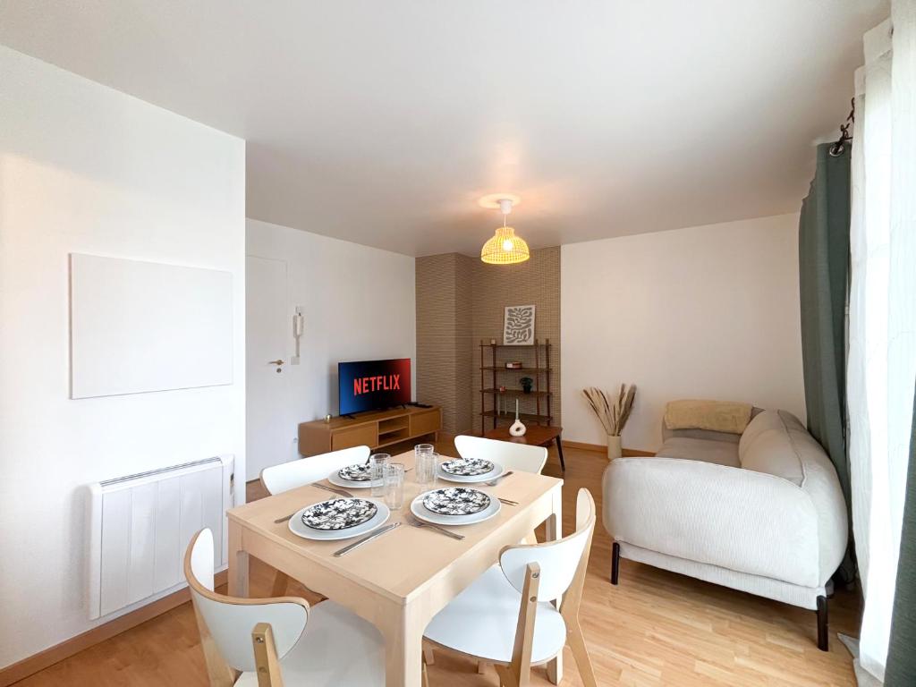 un salon avec une table, des chaises et un canapé dans l'établissement 10min de Disney Duplex 2ch avec Parking & Balcon, à Bailly-Romainvilliers