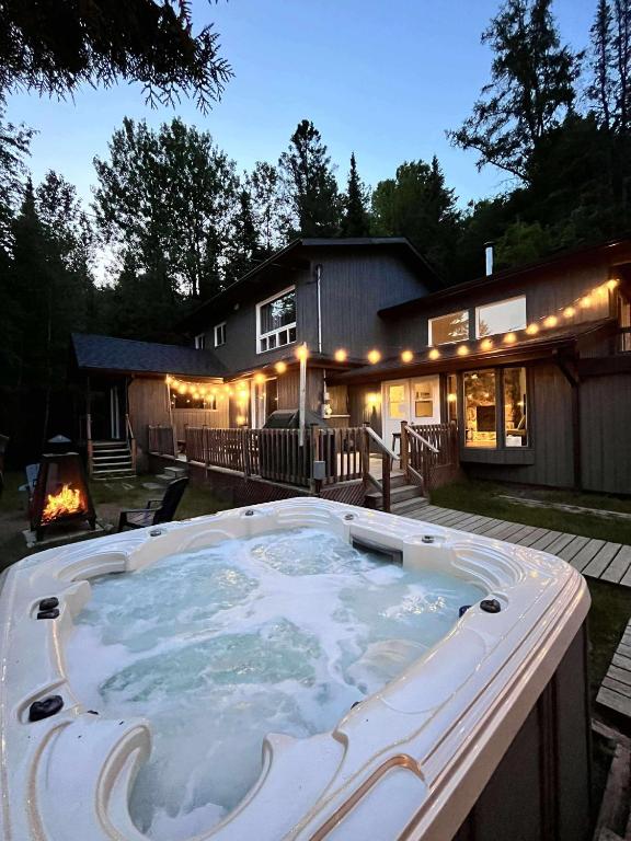 a large hot tub in front of a house at Le Alesund, 5BR avec SPA, PLAGE et embarcations in Sainte-Lucie-de-Doncaster