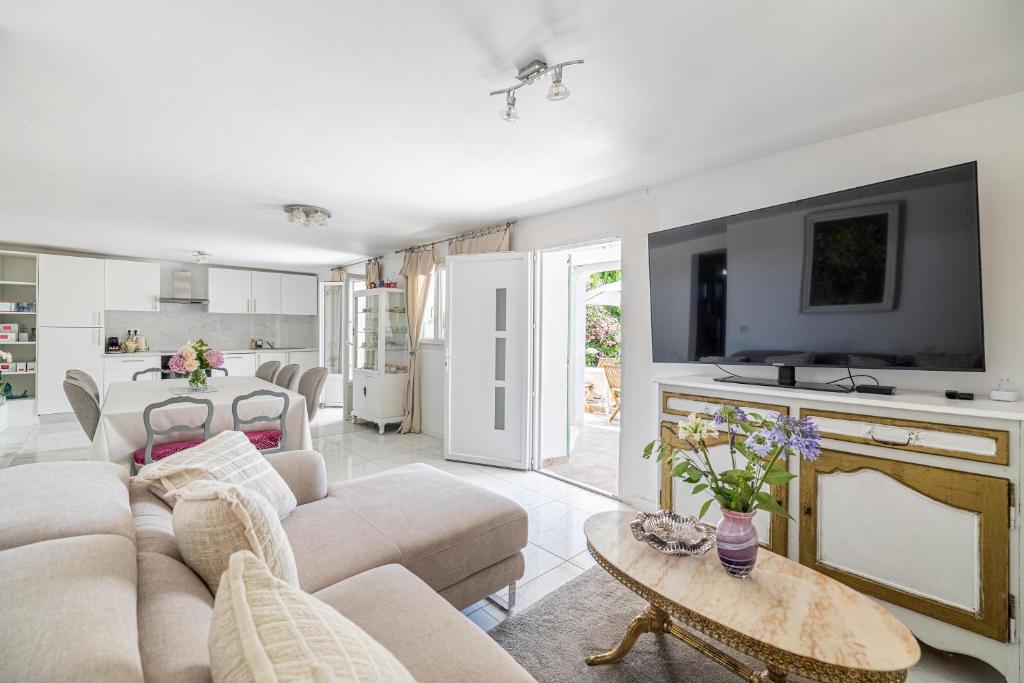 a living room with a couch and a table at LA VILLA DES FLEURS en duplex avec jardin et piscine in Le Cannet