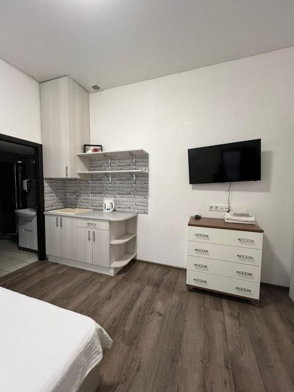 a bedroom with a bed and a tv on the wall at Royal Suite in Odesa