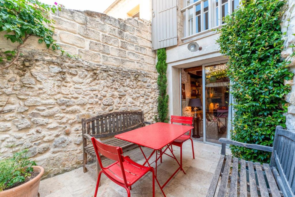 La Maison Dans Les Remparts في إج مورت: طاولة حمراء وكراسي بجوار مبنى