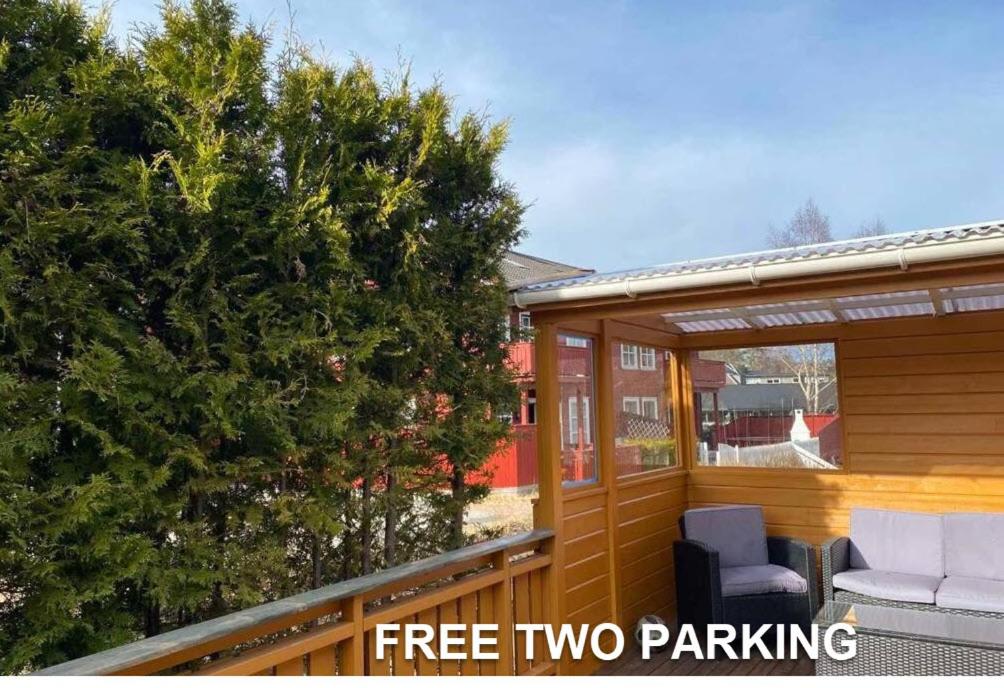 a screened porch with two chairs and a christmas tree at Marikollen, spacious appartment with sunny veranda in Kristiansand