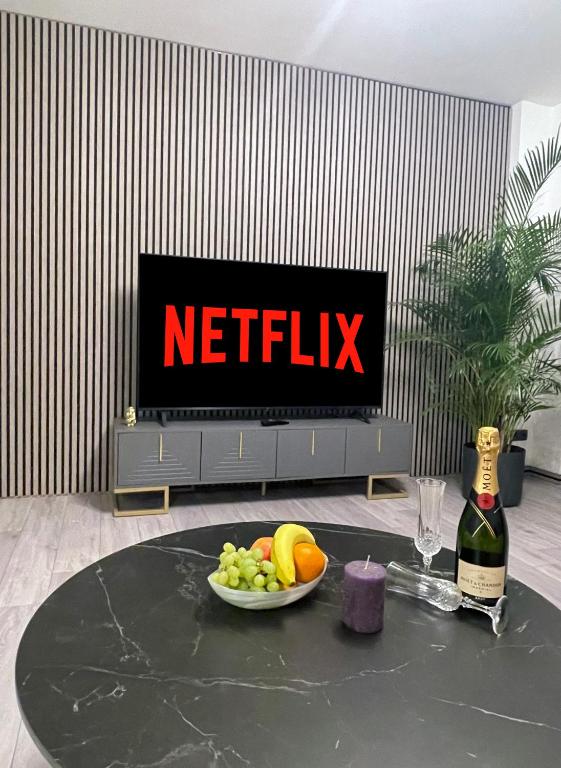 a table with a bowl of fruit and a tv at Metropolitan am Schloßpark in Paderborn