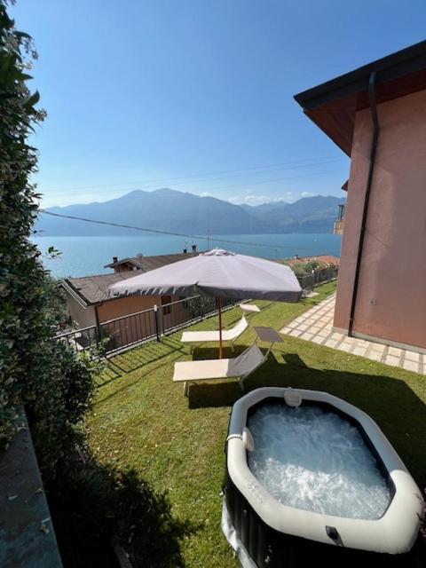 a bath tub sitting on the grass with an umbrella at Villa Anna in Brenzone sul Garda