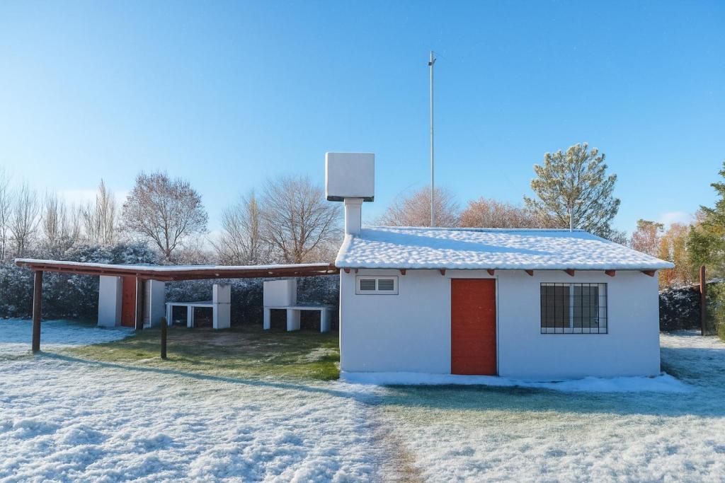 un piccolo edificio rosso e bianco nella neve di Cabañas Zelat a San Rafael