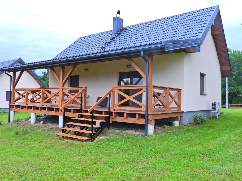 a large white house with a porch and a deck at Ostoja nad Gilem in Ostrów Wielki