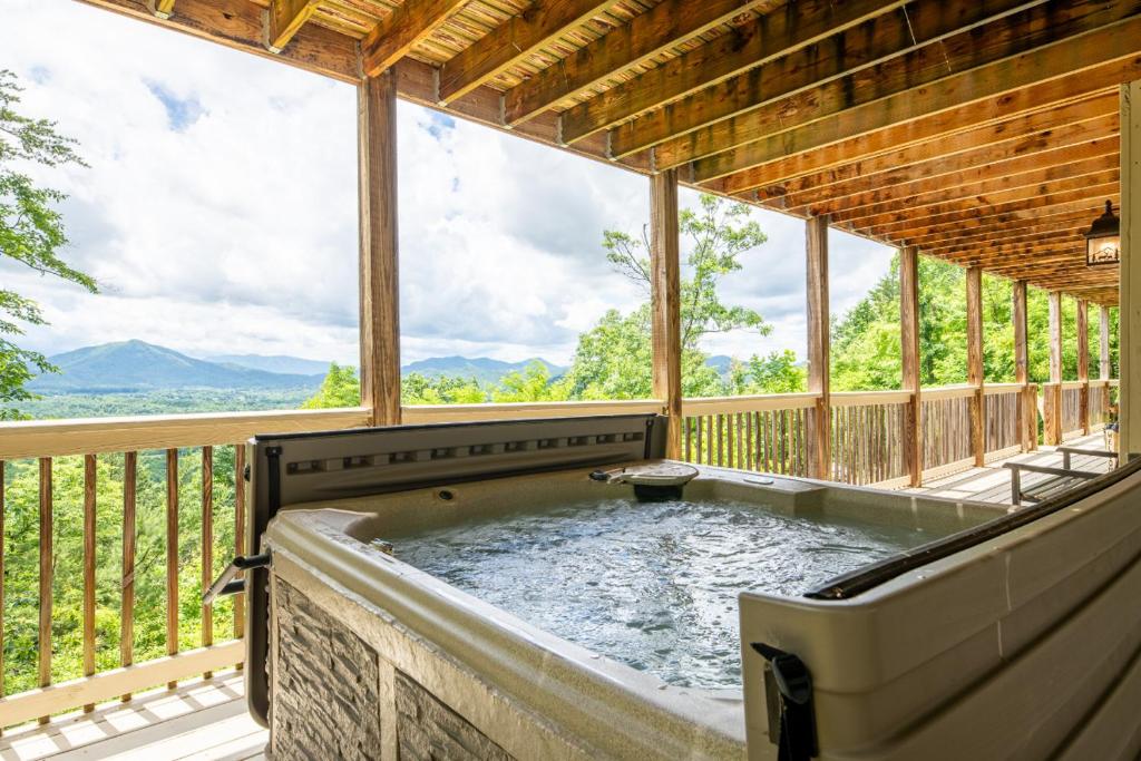 a hot tub on a screened in porch with a view at Starry Night Retreat By Avada Properties in Sevierville