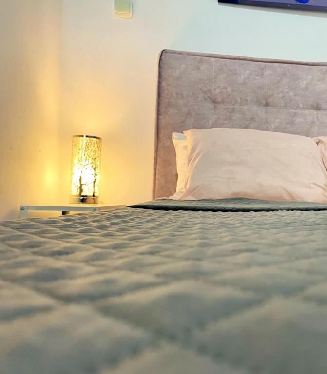 a bed with a white pillow and a lamp at Chora Suite in Mikonos