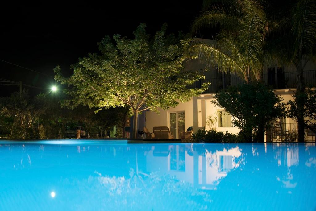 una piscina blu di notte con una casa di DELPOSTO Marina di Ragusa (dc) a Marina di Ragusa