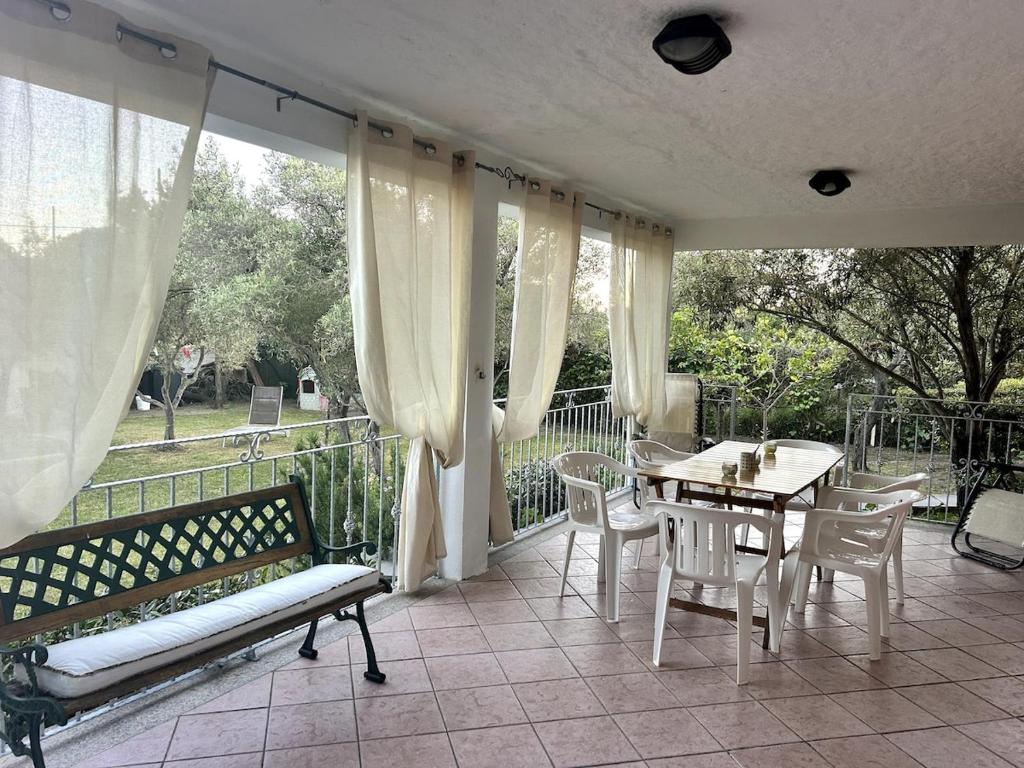 een veranda met een bank en een tafel en stoelen bij Casa Ginepro in Olbia