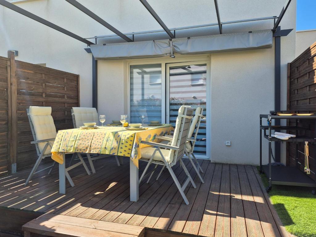 un patio avec une table et des chaises sur une terrasse dans l'établissement Le rêve au soleil les pieds dans l'eau - Villa 6 personnes en résidence avec piscine à 700 m des plages, à Sérignan