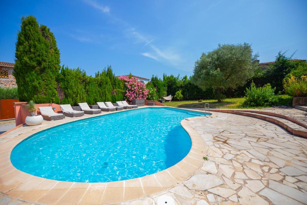 - une piscine dans une cour avec des chaises et des arbres dans l'établissement Mas Des Lavandes, à Mandelieu-la-Napoule