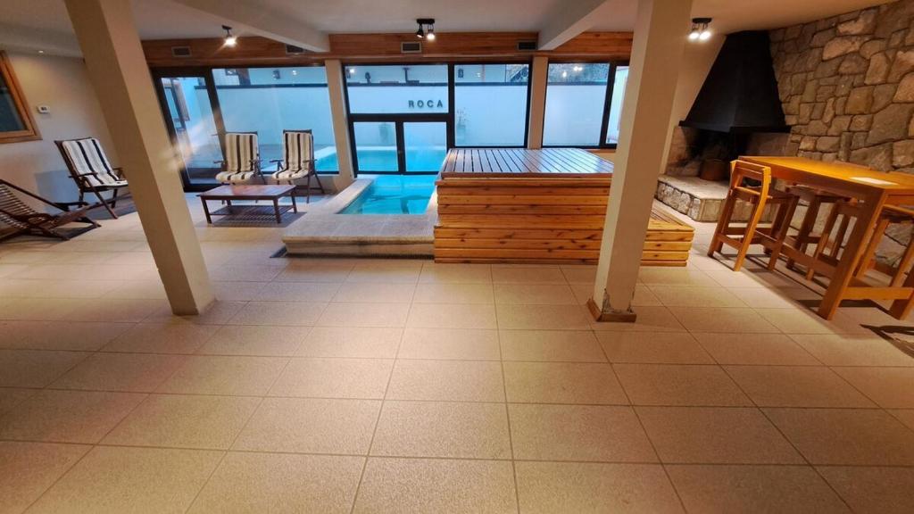 sala de estar con piscina y chimenea en Apart Roca - UF 103, en San Martín de los Andes