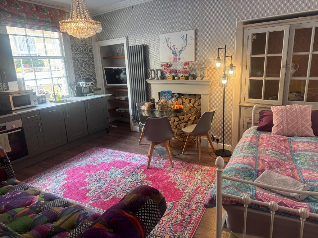 a bedroom with a bed and a table and a kitchen at Georgian city apartment at Thomas Street double bedroom and two single trundle beds in Bath