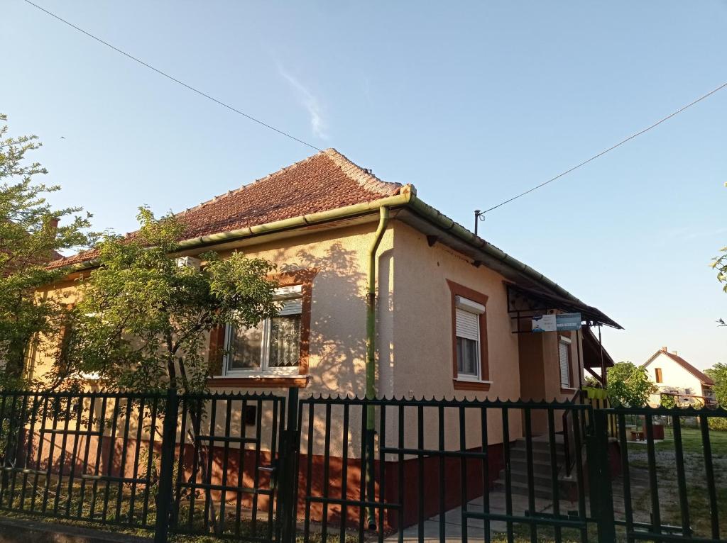 a small house with a fence in front of it at Hattyú vendégház Poroszló in Poroszló