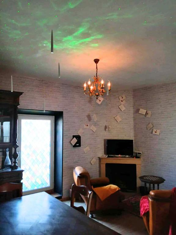 a living room with a chandelier and a fireplace at Séjour de sorcier Clim et Jardin in Saint-Privat
