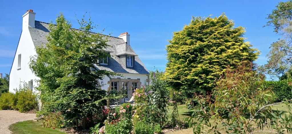 une vieille maison blanche avec des arbres dans la cour dans l'établissement BnB La Néo Bretonne, à Minihy-Tréguier