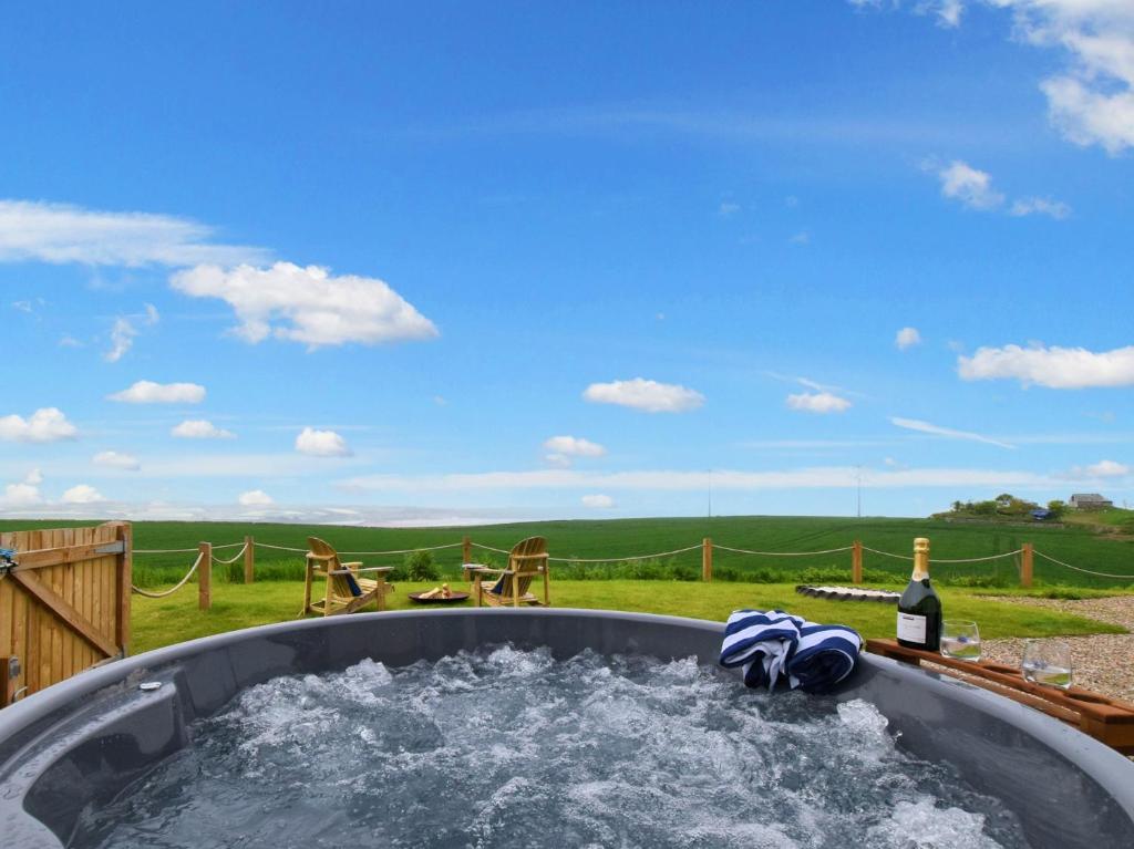 a hot tub with water and a bottle of wine at 3 Bed in Montrose 90784 in Inverkeilor