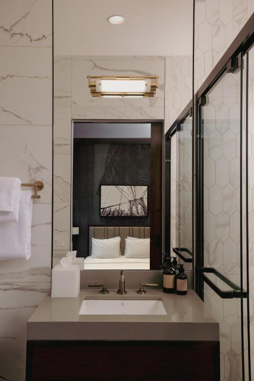 a bathroom with a sink and a large mirror at The Cloud One New York-Downtown, by the Motel One Group in New York