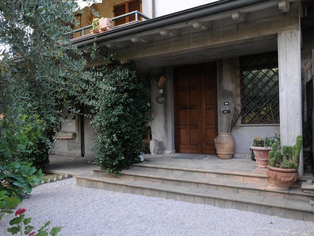 dom z drewnianymi drzwiami i roślinami w obiekcie B&B Luce Riflessa w mieście Perugia