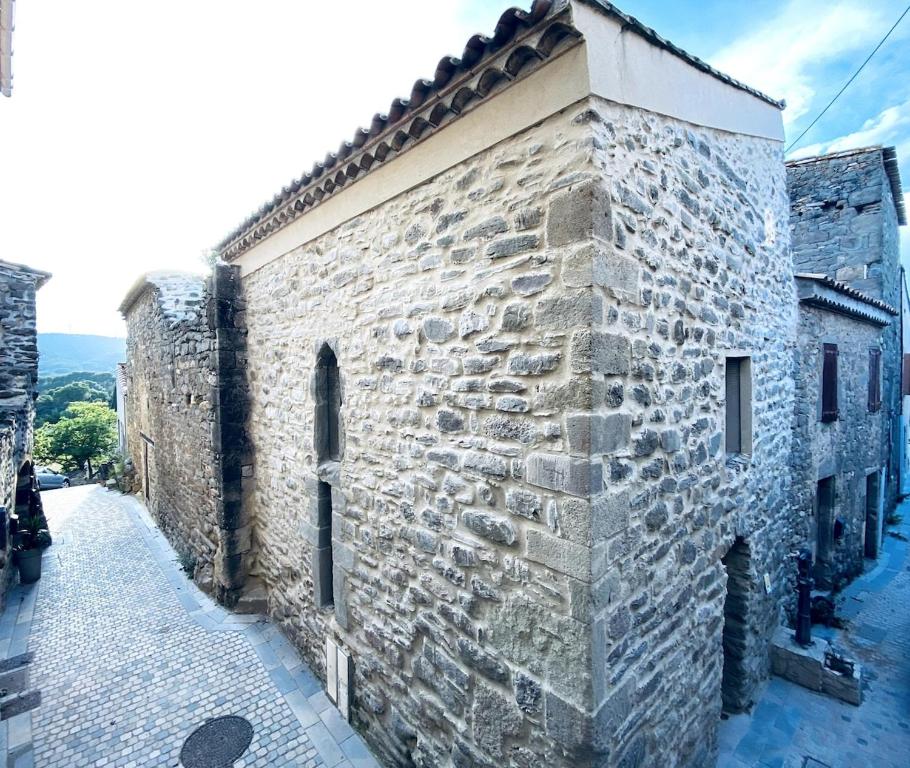 un antiguo edificio de piedra con una pared de piedra en Le Bastion, 15 guests, 5 suites, 5 baths, AC, en Pouzols-Minervois
