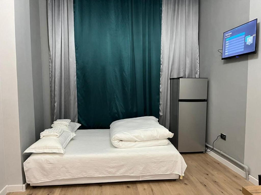 a bedroom with two beds and a flat screen tv at Etalon Apartment in Zhezdi