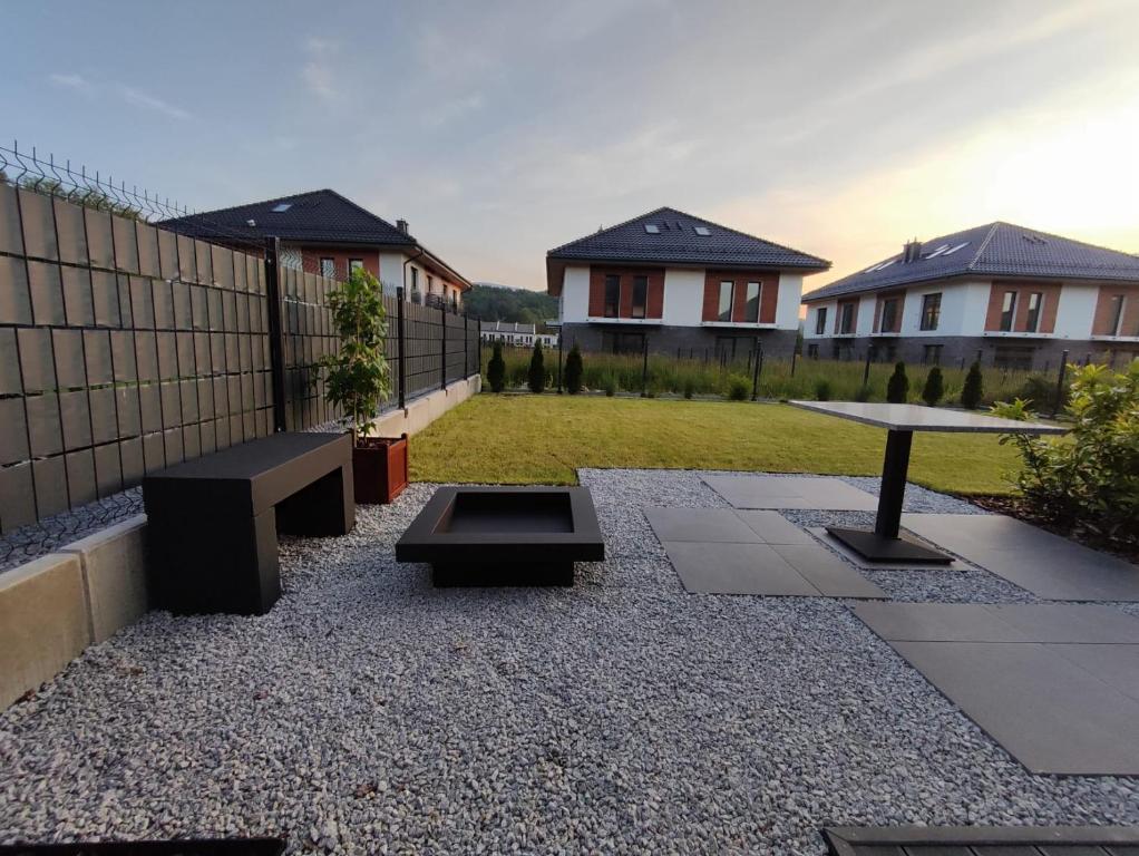a patio with two benches and a table in a yard at Apartamenty w Sercu Sosnówki in Sosnówka